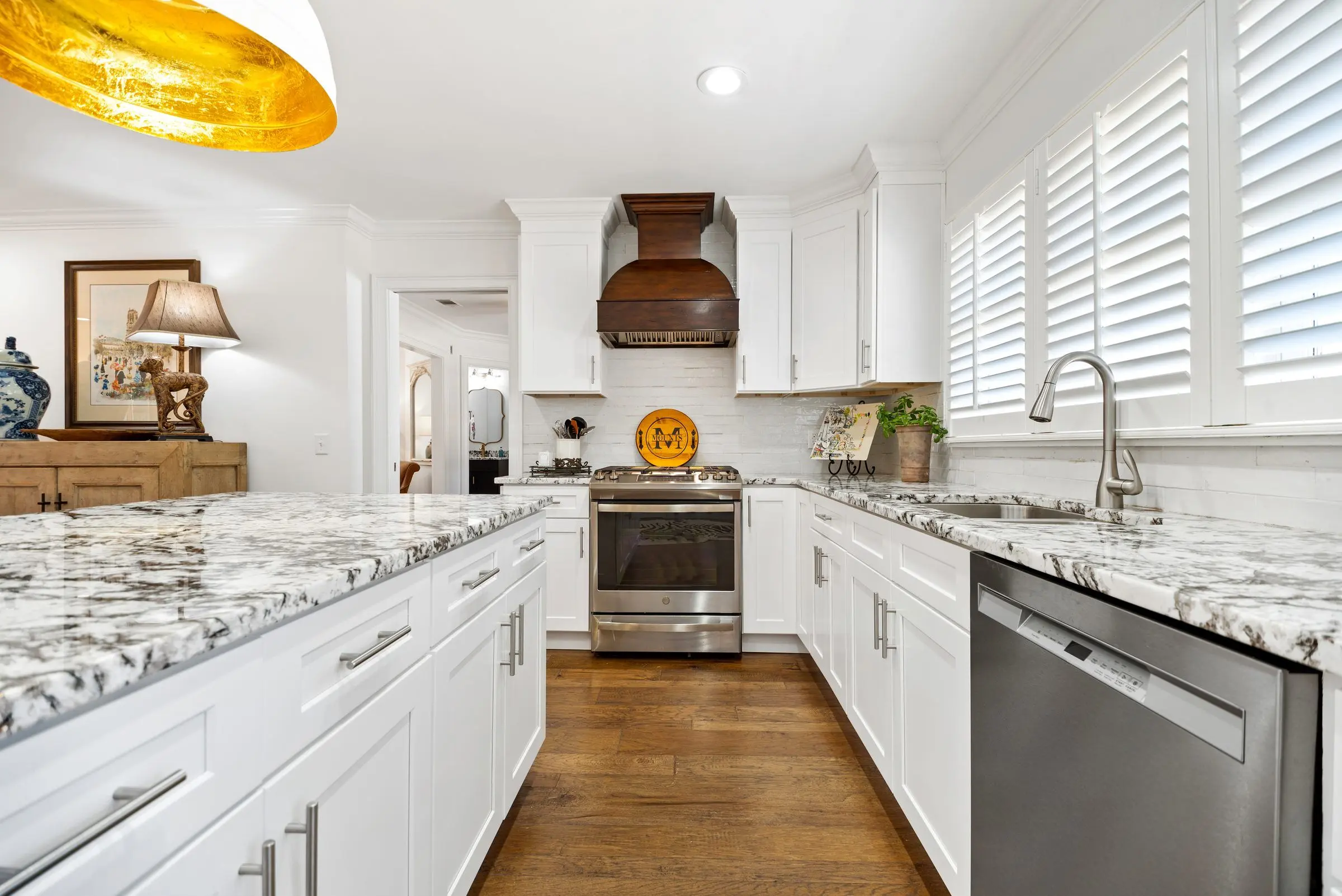 White kitchen with granite counters and a range hood