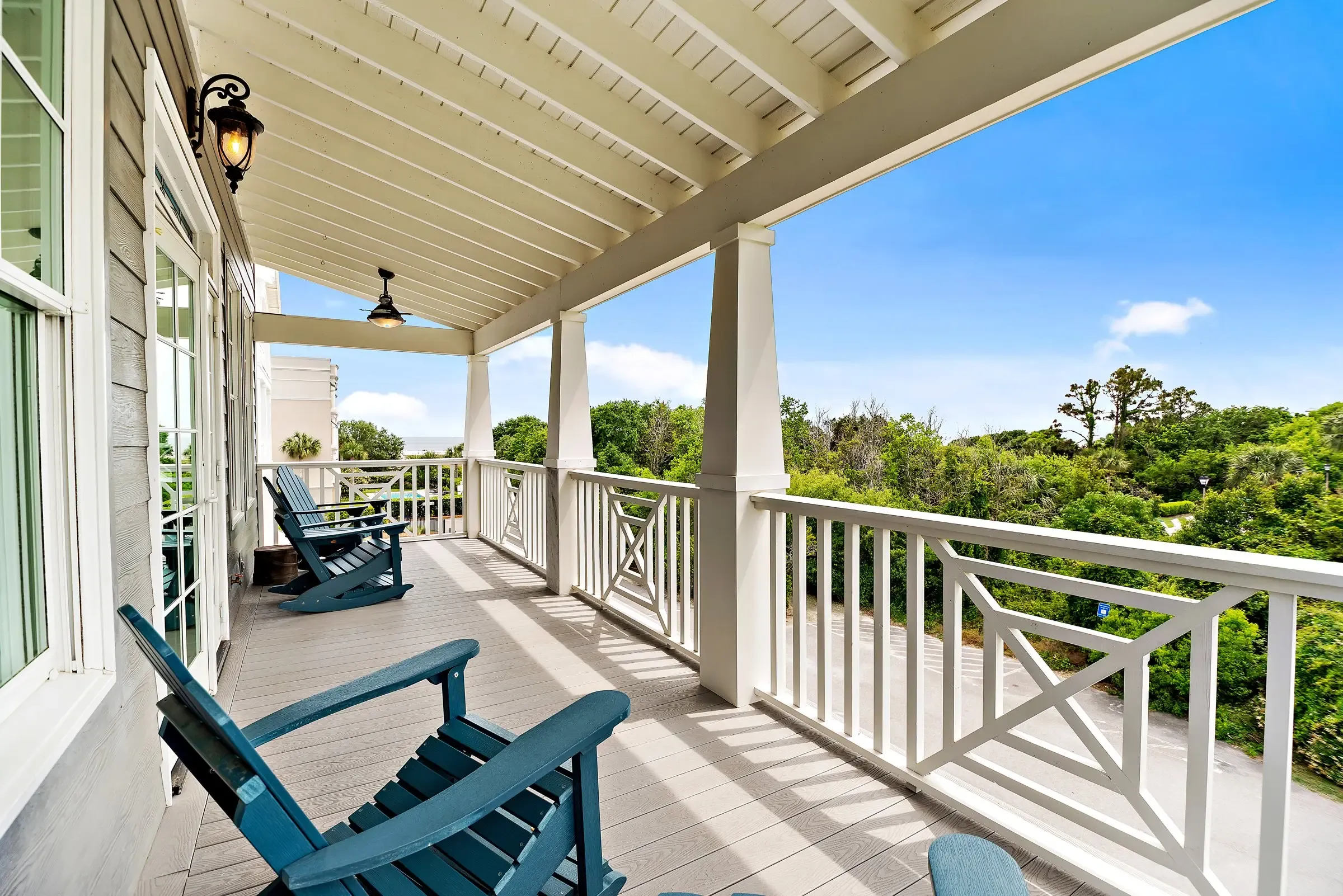 Covered porch with Adirondack chairs and a view of the yard